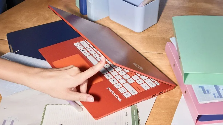 A red Packard Bell DotBook laptop open on a desk with colorful stationery.